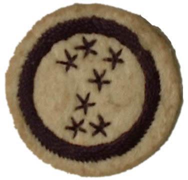 Image of round white felt badge with image of great bear constellations embroidered in navy thread, within a stitched navy ring.