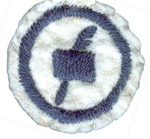 Round white felt badge. Within a stitched navy ring a stitched navy piece of paper landscape upon a stitched navy feather quill pen, all embroidered in navy thread and surrounded by an embroidered navy ring