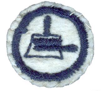 Image of a round white felt badge with a logo of a brush and dustpan embroidered in navy thread, within a navy embroidered ring.