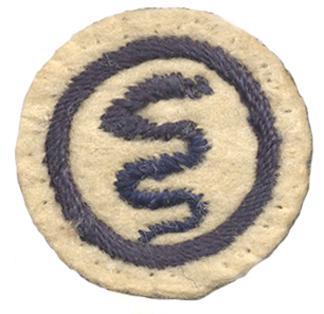 Image of a round white felt badge with a logo of a serpent embroidered in navy thread, within an embroidered navy ring.