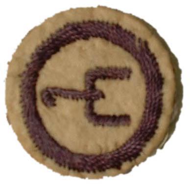 Image of round white felt badge embroidered with a navy spur logo within a navy embroidered ring