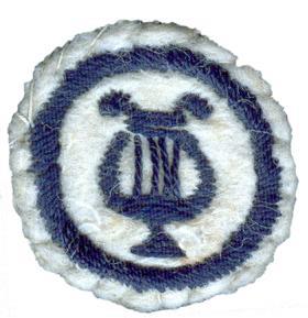 Image of round felt badge with a logo embroidered in navy thread, within a navy embroidered ring.