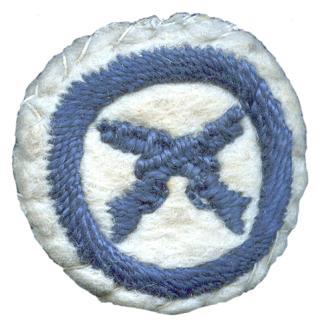photo of round white felt badge with logo of crossed rifles embroidered in dark blue inside a dark blue embroidered ring.