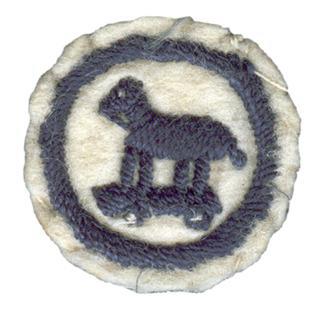 Photo of round white felt badge with a logo of a wooden toy horse on wheels stitched in dark blue thread within a navy embroidered ring.
